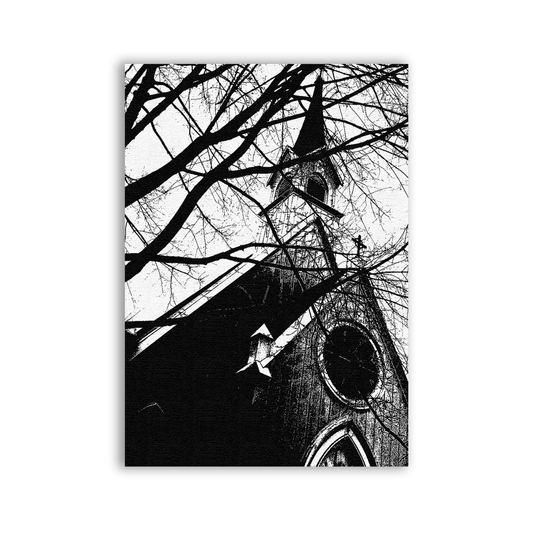 Black and white image of a church spire with bare tree branches.