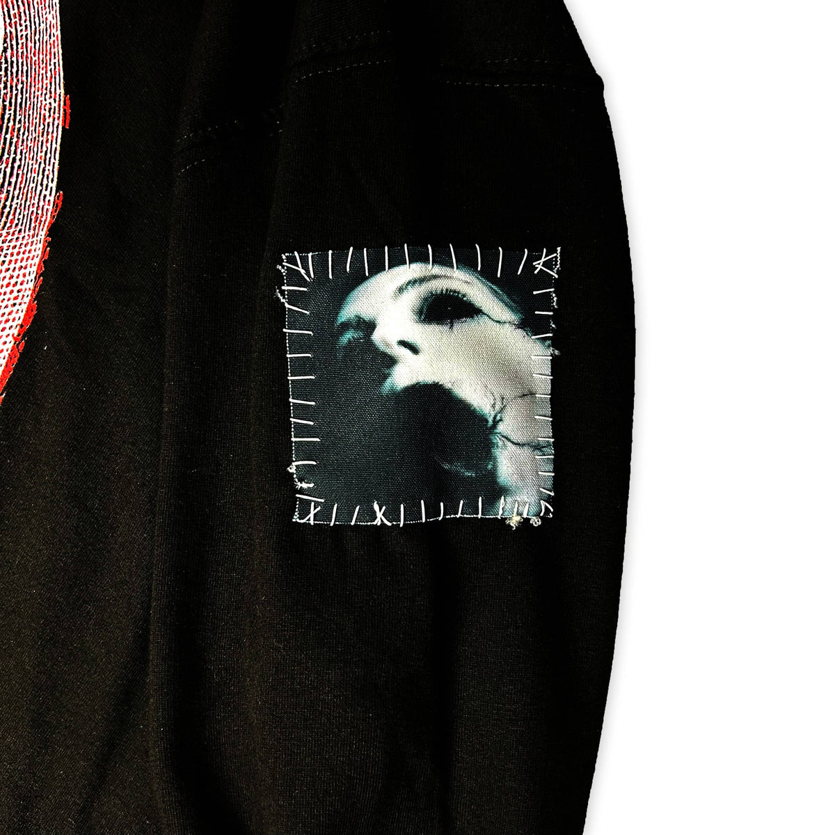 Close-up of the Graveyard Hoodie showing a stitched square patch with a white horror portrait