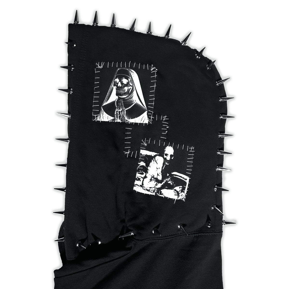 Close-up of the Hell’s Cemetery Hoodie hood showing framed white portraits and silver spikes
