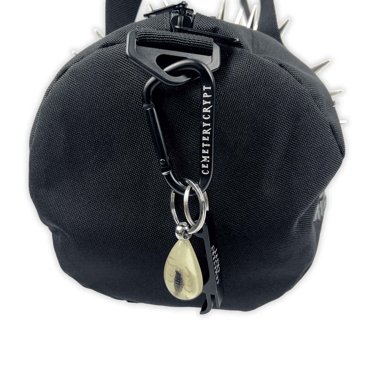 Close-up of the Mini Terror Barrel Bag end showing the zip, strap clip and yellow teardrop keyring