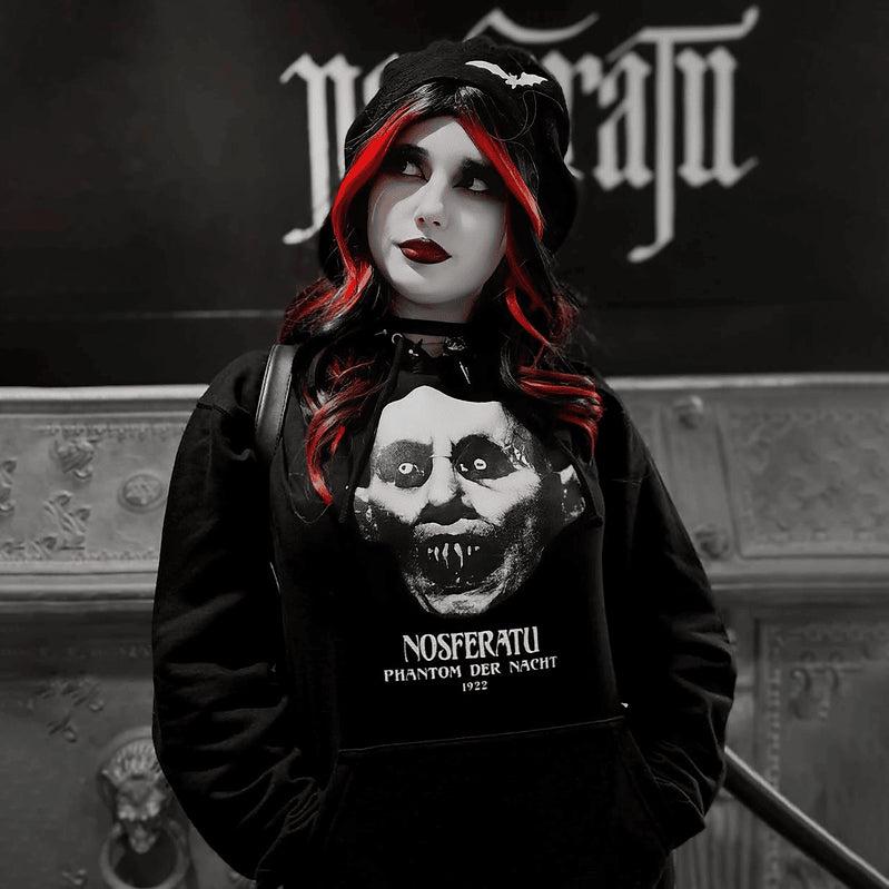 Model wearing the black Nosferatu Hoodie with the hood up and a large white vampire portrait on the front