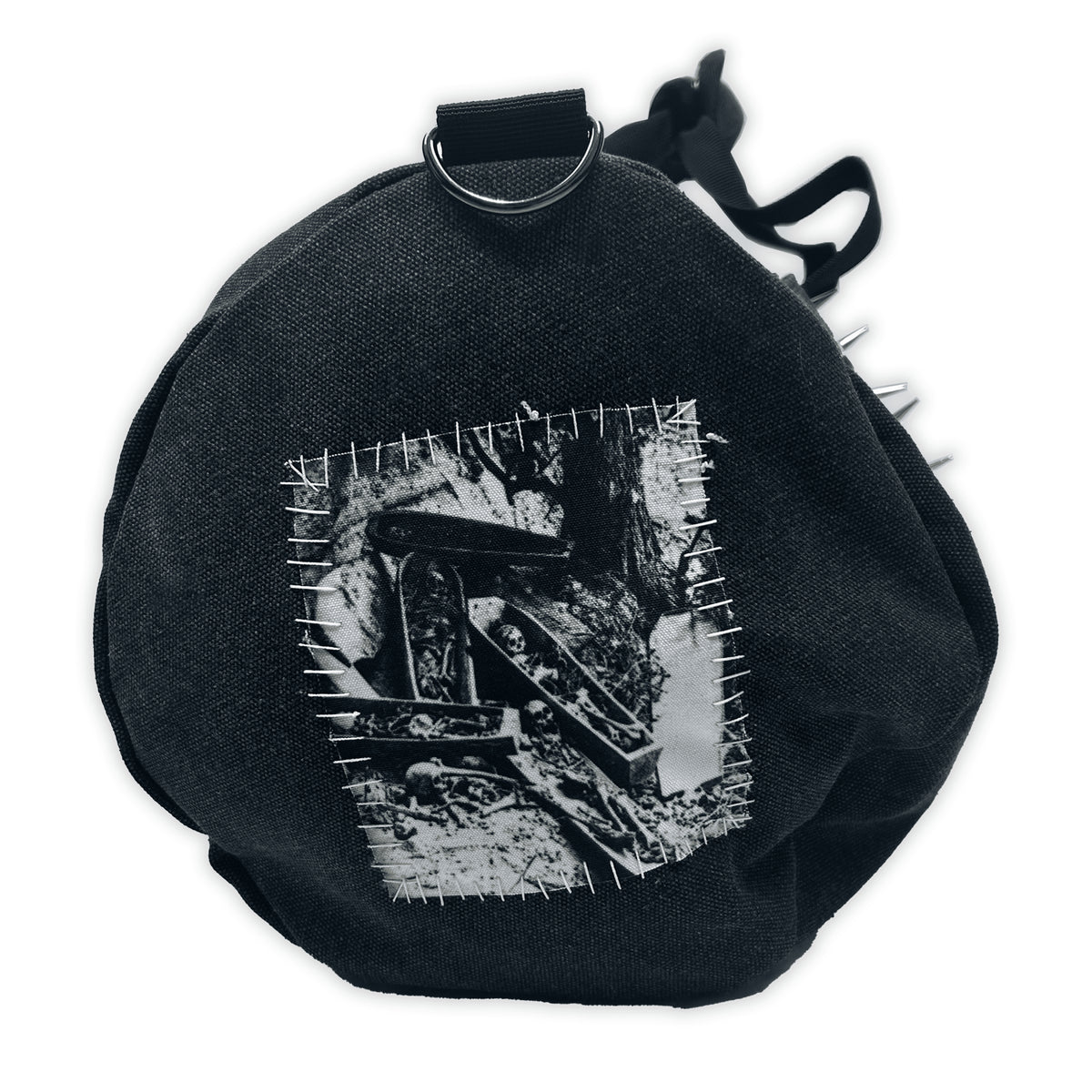 Round end of the Terror Barrel Bag with a black-and-white horror collage patch and metal spikes along the edge
