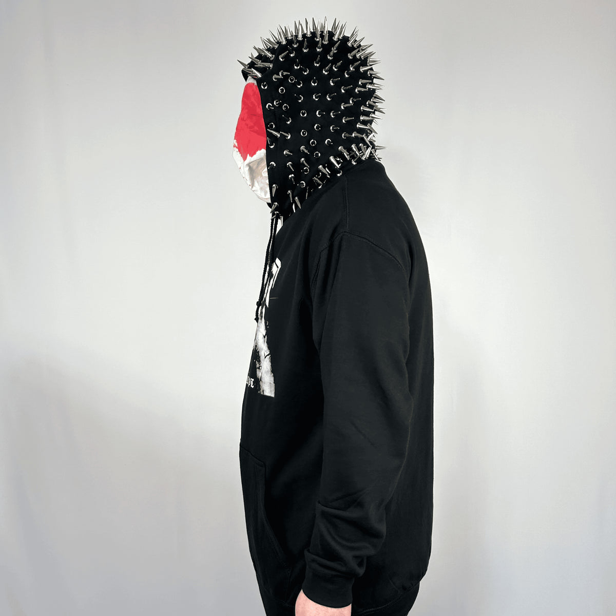 Side view of a model wearing the Terror Hoodie, showing the spike-covered hood and front print